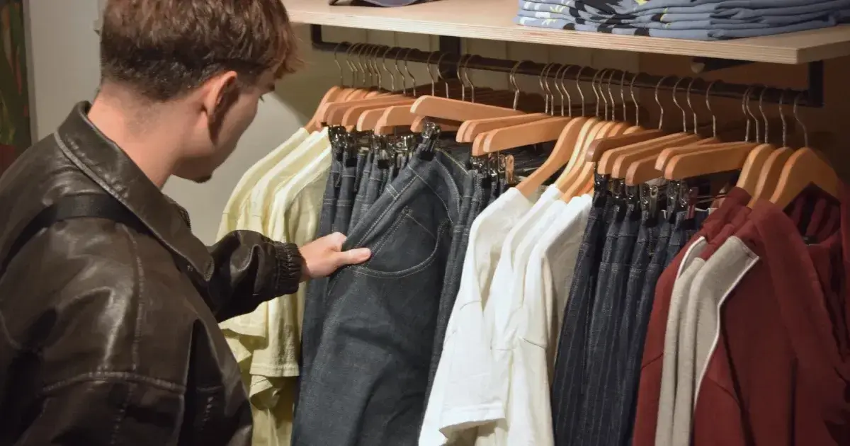 Man looking through clothing on hangers