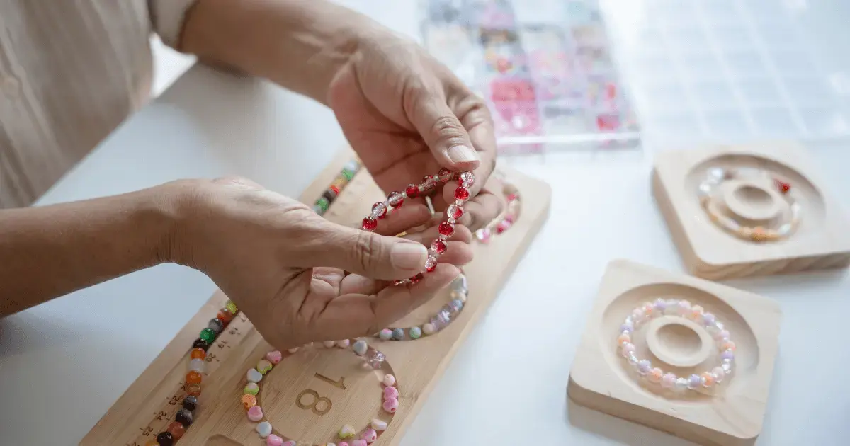 Person making beaded bracelets